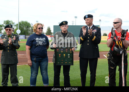 Il Mag. Gen. Al Dohrmann, il Dakota del Nord aiutante generale, secondo da destra, tubicini per ex U.S. Esercito e berretto verde, veterano di guerra di Vietnam David Halcrow, terzo da destra, dopo la presentazione di lui un shadowbox contenente numerose medaglie durante un apprezzamento militare cerimonia di notte presso FM RedHawks baseball gioco a Newman campo esterno, Fargo, N.D., 29 giugno 2017. Halcrow era stato ferito due volte durante il suo servizio come un U.S. Le forze speciali degli stati in Vietnam e ricevuto il cuore viola medaglia fra quelli presentati a lui al gioco. Egli non aveva ricevuto le medaglie prima della cerimonia. (U.S. Aria compit Foto Stock