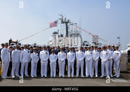 L'equipaggio di stanza a bordo del guardacoste attivo in posa per una foto di gruppo dopo il cambiamento di comando cerimonia tenutasi presso la guardia costiera Stazione aria Port Angeles, Washington, 30 giugno 2017. La guardia costiera della Cmdr. Christofer L. tedesco alleviato la Cmdr. Benjamin D. Berg come il comandante della attivo dopo essere stazionati a bordo della nave per un periodo di due anni. Stati Uniti Coast Guard foto di Sottufficiali di seconda classe Flockerzi Ali. Foto Stock