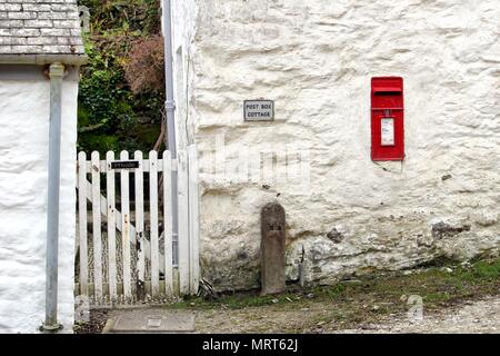 Colchester, Regno Unito - 12 Aprile 2018: una tradizionale britannica Royal Mail Post Office casella postale, impostare in un rustico ruvido muro bianco con un segno dire Foto Stock