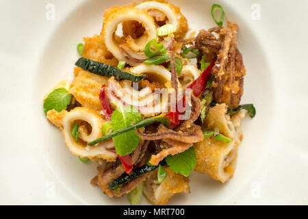 Calamari fritti Calamari tentacolo con peperoncino e foglie di menta Foto Stock