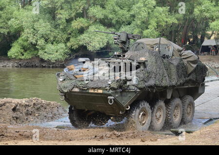 GYOR, Ungheria - veicoli militari appartenenti al primo squadrone, 2° reggimento di cavalleria, Vilseck, Germania, viaggi attraverso il PMP ponte galleggiante, oltre il Fiume Danubio durante una prova di attraversamento del fiume a Gyor, 4 luglio. Il ponte è impiegato dal 837th ingegnere vigili del Battaglione, Ohio National Guard e xxxvii reggimento ingegnere ungherese, forze di terra. L'esercizio, Szentes Ax, ungherese-led esercizio sotto Saber Guardian, facilita la libertà di movimento per il 2° reggimento di cavalleria come l'unità si muove in Romania per di più la formazione con gli alleati della NATO e partner. Saber Guardian è il più grande exercis Foto Stock