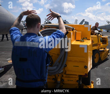 Sul mare del sud della Cina (Luglio 5, 2017) DEGLI STATI UNITI Aviazione Navale di Boatswain Mate Airman Forrest Francesco, da Houston, dirige un vuoto mobile mosso da U.S. Lancia Marine Cpl. Dakota Buer, da Milwaukee, sul ponte di volo a bordo della portaerei USS Nimitz CVN (68), 5 luglio 2017, nel Mare della Cina del Sud. Nimitz è attualmente sulla distribuzione negli Stati Uniti 7 flotta area di operazioni. Gli Stati Uniti Marina ha pattugliato il Pacifico Indo-Asia di routine per più di 70 anni regionale di promozione della pace e della sicurezza. (U.S. Foto di Marina di Massa lo specialista di comunicazione di terza classe Weston A. Mohr) Foto Stock