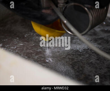 Il taglio a getto abrasivo macchina situato nel negozio di fabbricazione del 379 Manutenzione Expeditionary Squadron utilizza una velocità elevata corrente coerente di 98% di acqua e 2% di sabbia per tagliare attraverso quasi qualsiasi materiale di Al Udeid Air Base, Qatar, Giugno 5, 2017. Il taglio a getto abrasivo macchina consente la aviatori di creare una vasta gamma di parti di aerei o gli attrezzi necessari per completare la missione in un accelerato e un modo economicamente conveniente. (U.S. Air Force foto di Tech. Sgt. Amy M. Lovgren) Foto Stock