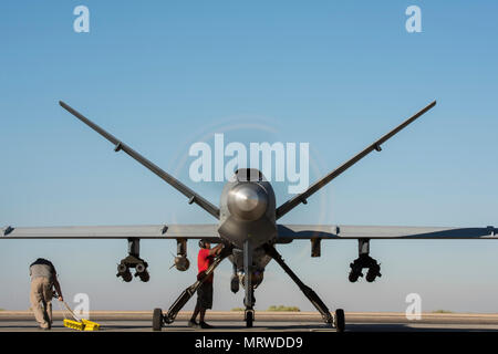 I manutentori di eseguire il preflight finale delle procedure prima di un MQ-9 Reaper, blocco 5 variante, prendendo il largo 23 giugno 2017, nel sud-ovest Asia. Questo ha segnato il blocco del primo volo di combattimento a sostegno di funzionamento inerenti a risolvere. (U.S. Air Force foto/Senior Airman Damon Kasberg) Foto Stock