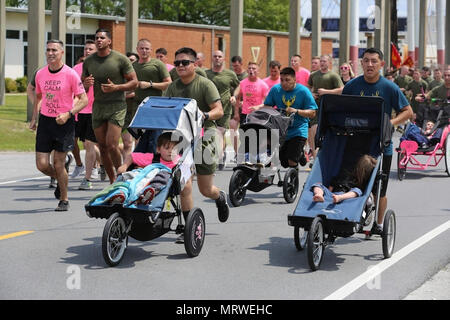 Marines spingere atleta piloti lungo il lato di altri Marines durante una formazione girare al Marine Corps Air Station New River, N.C., 13 aprile 2017. Più di 220 marines assegnato a Marino Logistica Aerea Squadron 26, Marine Aircraft Group 26, seconda Marine Ala di aeromobili sono venuti insieme per eseguire con bambini disabili per un Ainsley's Angels East Carolina capitolo evento. Il gruppo ha partecipato all'evento per mostrare il loro sostegno per la comunità locale e di condividere le loro Espirit de Corps. ( U.S. Marine Corps Foto Stock