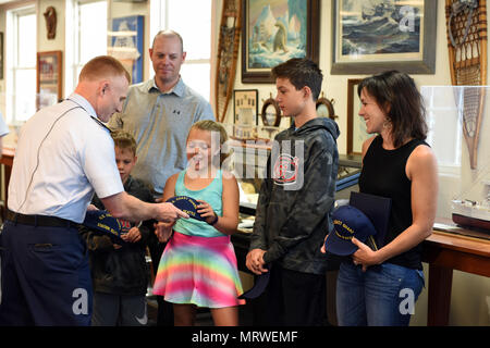 Adm posteriore. David Throop, commander, Coast Guard tredicesimo distretto, presenta Darci Dawson e i membri della sua famiglia con Stazione della Guardia Costiera Seattle cappelli dopo dando Dawson il meritorio servizio pubblico Premio Base a Seattle, Luglio 7, 2017. Dawson è stato riconosciuto per la sua generosa azioni dopo che ha salvato la vita di un bambino di annegamento, Kaden Sluggett, il 9 luglio 2016, mentre è in vacanza in Montana. Stati Uniti Coast Guard foto di Sottufficiali di seconda classe Flockerzi Ali. Foto Stock