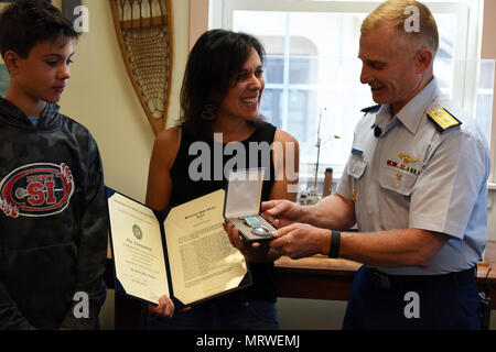 La guardia costiera Adm posteriore. David Throop, commander, Coast Guard tredicesimo distretto, presenta il servizio meritevole medaglia a darci Dawson presso la Guardia Costiera di base Museo di Seattle il 7 luglio 2017, per la sua generosa azioni dopo che ha salvato la vita di un annegamento 18-mese-vecchio toddler nel 2016. Kaden Sluggett vagato in un torrente e quasi affogato quando Dawson ha scoperto lui, somministrati CPR e rianimati con successo a lui mentre in transito per soddisfare un'ambulanza. Stati Uniti Coast Guard foto di Sottufficiali di seconda classe Flockerzi Ali. Foto Stock