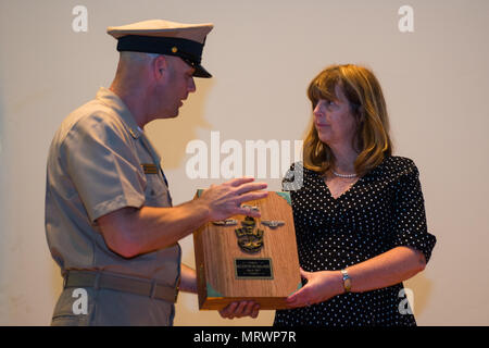 NORFOLK (Luglio 6, 2017) Senior Chief la comunicazione di massa Specialist Jim Perkins, assegnato al navale attività di supporto est, presenta Katherine "Kathy" McRill-Fellini, vedova di Robert "Bobby" McRill, una carica simbolo Libro dall'Hampton Roads Area Chief's pasticcio durante una cerimonia in cui McRill è stato promosso a Capo onorario Petty Officer. McRill fu ucciso in azione durante l'Operazione Iraqi Freedom il 6 Luglio 2007 da na improvvisato dispositivo esplosivo. (U.S. Marine Expeditionary combattere la foto della telecamera tramite la comunicazione di massa specialista in seconda classe Ridge Leoni) Foto Stock