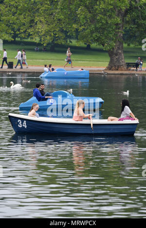 Persone sedersi in pedalò e barche a remi sulla serpentina in Hyde Park, Londra. Foto Stock