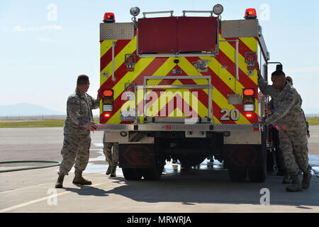 I vigili del fuoco e gli ospiti di presenze spingere il nuovo pennello carrello nel veicolo la baia di storage durante il dipartimento dei vigili del fuoco del camion di cerimonia di battesimo Luglio 6, 2017, a Malmstrom Air Force Base, Mont. Questa parte della cerimonia rende omaggio ad una vecchia tradizione risalente al a cavallo il pumper giorni. (U.S. Air Force foto/Airman 1. Classe Daniel Brosam) Foto Stock