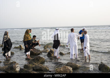 Pellegrini in cammino sulle rocce nel Mare Rosso durante il Ramadan di Jeddah, Arabia Saudita Foto Stock