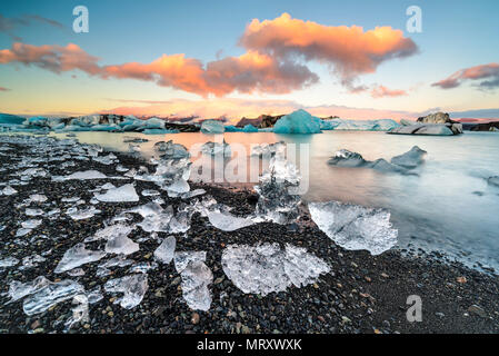 Jokulsarlon, Islanda Orientale, Islanda, l'Europa del Nord. L'iconico piccoli icebergs rivestiti in laguna glaciale durante un sunrise Foto Stock