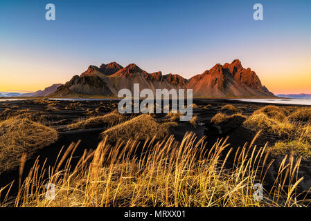 Stokksnes, Hofn, orientale, Islanda Islanda. Vestrahorn mountain e il nero dune di sabbia al tramonto. Foto Stock