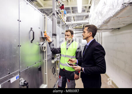 Il lavoratore e il manager in quadri di controllo camera di impianto CNC Foto Stock