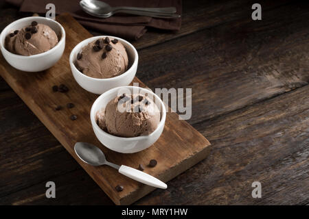 Gelato al cioccolato su sfondo di legno, copia dello spazio. In casa vegan cheto gelato al cioccolato con scaglie di cioccolato - sano dessert estivo. Foto Stock