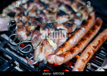 Barbecue spiedini spiedini di carne sulla griglia fiammeggianti Foto Stock