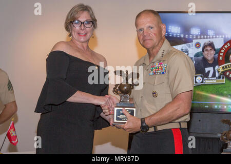 Il comandante del Marine Corps gen. Robert B. Neller, destra stringe la mano ad Ilaria San Giovanni, nipote di Clifford battaglie, DURANTE GLI STATI UNITI Marine Corps Sports Hall of Fame cerimonia di investitura presso il Museo Nazionale del Marine Corps, Triangolo, Virginia, luglio 12, 2017. Battaglie entrato a far parte della National Football League nel 1931 e ha giocato per la Boston Braves fino al 1937 e servito come una preparazione atletica e ricreazione Officer negli Stati Uniti Marine Corps dal 1943 al 1952. (U.S. Marine Corps foto di Cpl. Samantha K. Braun) Foto Stock