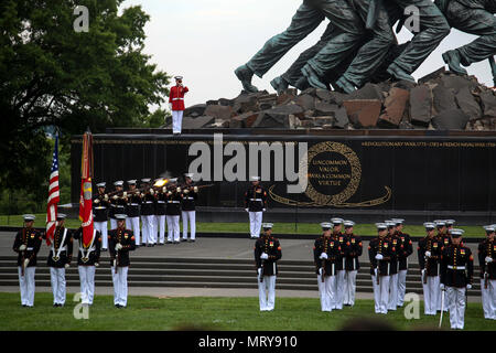 Marines con Bravo società partito di sparo, caserma marini di Washington D.C., rendere onori durante un martedì tramonto Parade presso il Marine Corps War Memorial, Arlington, Virginia, luglio 11, 2017. L ospite d onore per la parata è stata la onorevole Gerald Moran, U.S. Il senatore del Kansas, e l'hosting ufficiale è stato Lt. Gen. Michael Dana, vice comandante, impianti e logistica. La Parade featured noncommissioned officers in posizioni tradizionalmente tenuto da parte di funzionari e personale noncommissioned ufficiali come sfilata personale e il plotone e la leadership della società. (Ufficiale DEGLI STATI UNITI Marine Corps photo by Lance Foto Stock