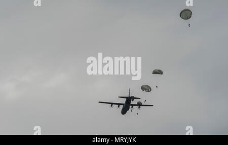 Paracadutisti da più paesi NATO saltare fuori di un U.S. Air Force C-130J Super Hercules durante il salto internazionale settimana, luglio 11, 2017. Oltre 500 membri del servizio sono stati fatti cadere oltre i cinque giorni di formazione e gli organizzatori sono stati in grado di chiudere la settimana senza importanti lesioni. (U.S. Air Force foto di Senior Airman Tryphena Mayhugh) Foto Stock