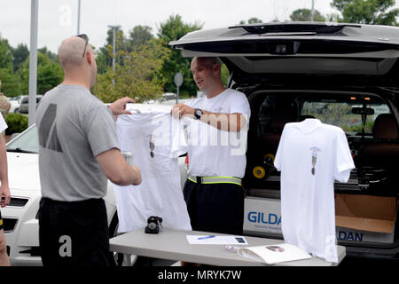 Esercito Capt. Sean quotidiano del North Carolina National Guard Direttore del Museo, mani le magliette per commemorare il centesimo compleanno di Old Hickory prima a tre miglia di eseguire in Raleigh, North Carolina, luglio 18, 2017. Old Hickory è stato stabilito durante la Prima Guerra Mondiale come il trentesimo divisione di fanteria. Durante il secolo l'unità è stato riorganizzato, attualmente è il trentesimo Armored Brigade Combat Team. (U.S. Esercito nazionale Guard photo by Staff Sgt. Maria Junell, 382 Affari pubblici Distacco/rilasciato) Foto Stock