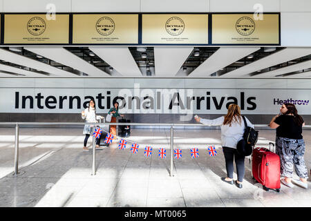 Persone in attesa presso il terminale 5 International Hall Arrivi all'aeroporto di Heathrow di Londra, Regno Unito Foto Stock