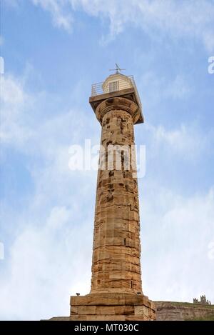 Il famoso faro alla fine del molo di Whitby. Whitby Abbey può essere visto sulla rupe in distanza. Foto Stock