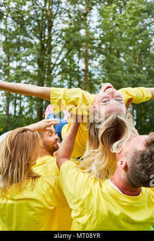 Il team di team building workshop treni fiducia e rende la donna galleggiante Foto Stock