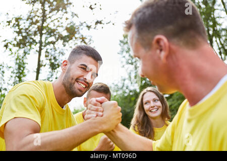 Due uomini misurare le forze nel braccio di wrestling, in corrispondenza di un evento di team building Foto Stock