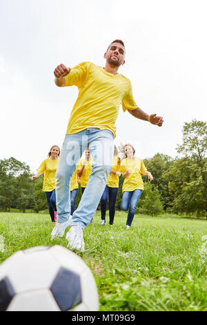 Giovane uomo facendo allenamento per il calcio con il suo team è di mettere in pratica un tiro in porta Foto Stock
