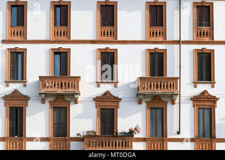 Elegante facciata di un tradizionale edificio europeo di appartamenti con finestre simmetriche e balconi con intricate finiture decorative, Foto Stock
