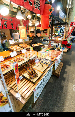 Piscina Omicho Ichiba, Mercato Omicho, fresco più grande mercato alimentare a Kanazawa, Giappone. Pesce bancarella vendendo take-away pesce su spiedini di legno. Foto Stock