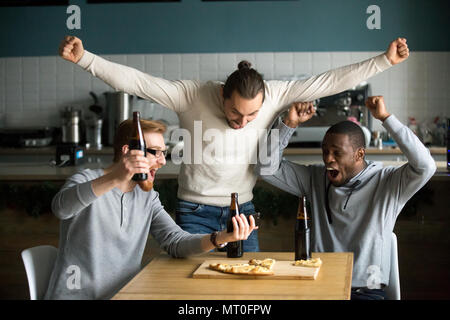 Uomini estatica celebrando la vittoria la visione di gioco su smartphone, sp Foto Stock