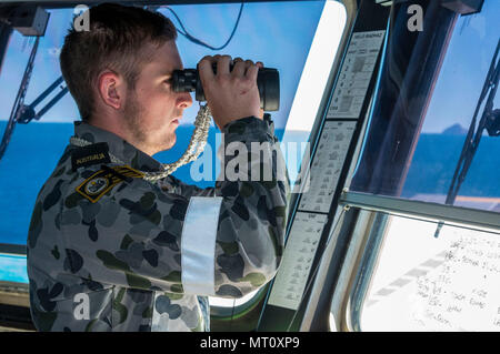 170720-N-DL434-109 CORAL SEA (Luglio 20, 2017) Royal Australian Navy Boatswain compagno del marinaio in grado Guss Buthmann sondaggi acque circostanti dal ponte della Royal Australian Navy Amphibious Assault nave HMAS Canberra (III) (L02) durante il talismano di Saber 17. Talismano Saber è una biennale U.S.-australiano esercizio bilaterale tenutosi al largo della costa australiana intende conseguire l'interoperabilità e rafforzare gli Stati Uniti-Australian alliance. (U.S. Foto di Marina di Massa Specialista comunicazione marinaio apprendista Gavin scudi/rilasciato) Foto Stock