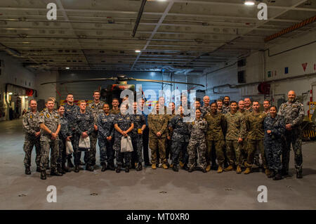 170720-N-DL434-149 CORAL SEA (Luglio 20, 2017) Marinai e Marines dall'assalto anfibio nave USS Bonhomme Richard (LHD 6) e Royal Australian marinai e soldati australiani in pausa per una foto sul ponte di hangar della Royal Australian Navy Amphibious Assault nave HMAS Canberra (III) (L02) durante un tour della nave. La visita è stata effettuata come parte di uno scambio di personale tra le due navi anfibio a fornire ai membri di entrambe le navi un opportunità di imparare a conoscere i doveri professionali e la vita personale dei loro omologhi, aumentando ulteriormente i legami che sono una parte fondamentale di talismano Saber 17. Tali Foto Stock