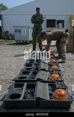 Ron Schultz, con la formazione del team di supporto (TST) Valcea, formazione Expeditionary divisione di assistenza, training di supporto attività Europa, ispeziona più laser integrato sistema di innesto (miglia) apparecchiature restituite da un soldato olandese, in Ramnicu Valcea, Romania, 20 luglio 2017. TST Valcea offre miglia di attrezzature per le varie nazioni della NATO che parteciperanno a contatto simulato durante un divario umido traversata attraverso il Fiume Olt, come parte dell'esercizio Saber custode. Saber Guardian è un esercizio di multinazionali che si estende attraverso la Bulgaria, l Ungheria e la Romania con più di 25.000 membri del servizio Foto Stock