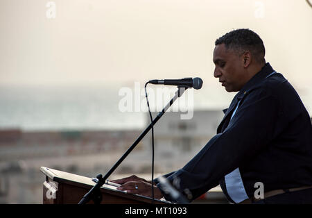 BAHRAIN (16 aprile 2017) della Cmdr. John Logan, un cappellano della Marina Militare a bordo della portaerei USS George H.W. Bussola (CVN 77) (GHWB), legge una preghiera durante un sunrise servizio Pasqua svoltasi sul ponte di volo. GHWB è distribuito negli Stati Uniti Quinta Flotta area di operazioni a sostegno della sicurezza marittima operazioni destinate a rassicurare gli alleati e partner e preservare la libertà di navigazione e il libero flusso di commercio nella regione. Foto Stock