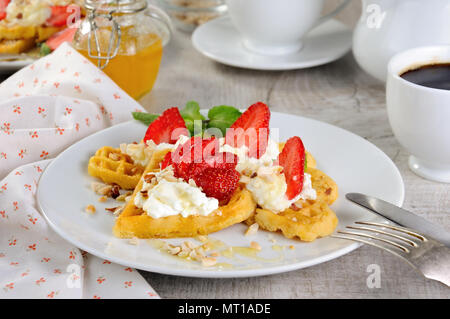 Delicato, fusione gustose cialde belghe con panna montata, fragole aromatizzata con arachidi e miele. Che cosa ci potrebbe essere di meglio per dove siamo Foto Stock