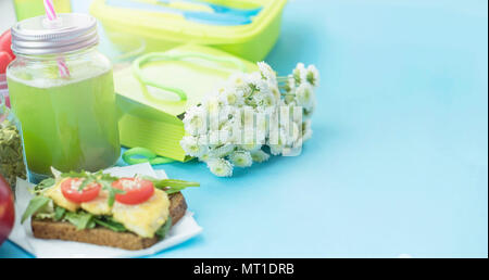 Banner sana colazione vegetariana. Sandwich di pane di grano con erbe e tofu, detox smoothie, Apple, semi di girasole, pomodori ciliegini, backgroun blu Foto Stock