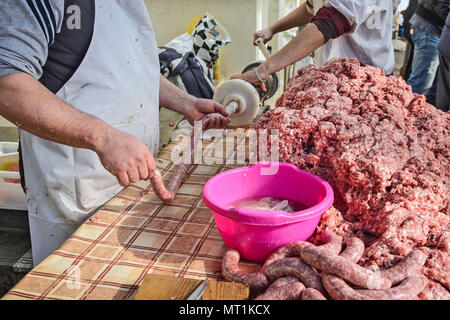 Il macellaio rende salsicce fatte in casa all'aperto in un modo tradizionale. Foto Stock