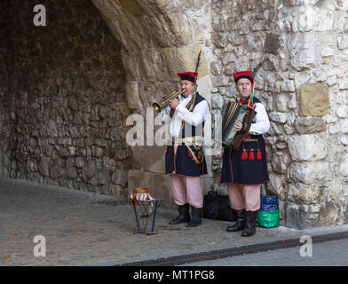 Cracovia in Polonia - Ottobre 28, 2015: musicisti di strada in costumi nazionali dalle mura della città vecchia di Cracovia Foto Stock