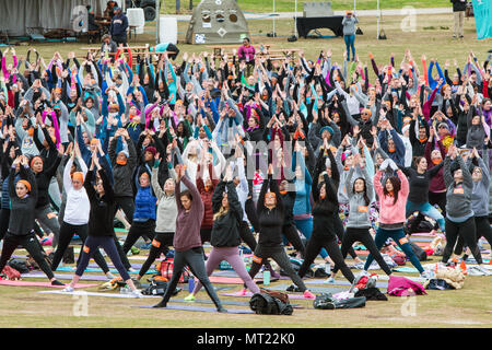 Decine di persone e non la versione di saluto verso l'alto si presentano come essi prendono parte in un massiccio gruppo classe di yoga in Piemonte Park di Atlanta, GA, 8 aprile 2018. Foto Stock