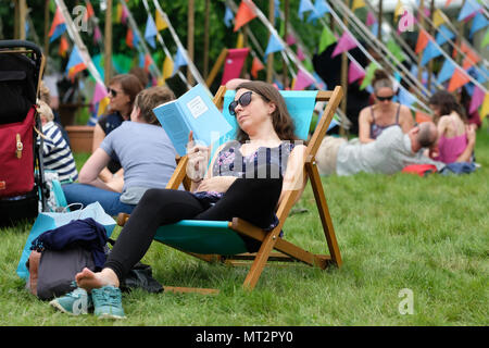 Festival di fieno, Hay on Wye, Regno Unito - Lunedì 28 Può 2018 - Regno Unito - Previsioni del tempo - lunedì festivo presso il Festival di fieno - visitatori apprezzano la possibilità di sedersi al Festival di sedie a sdraio e leggere i loro libri tra autore gli eventi su un caldo umido ma nuvoloso giorno - - Photo Steven Maggio / Alamy Live News Foto Stock