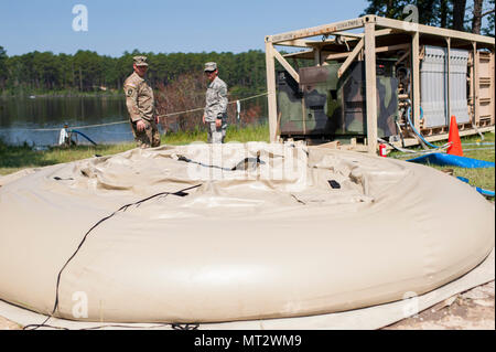 Stati Uniti La riserva di esercito di soldati con la 326Quartermaster Company, New Castle, Pa., controllare i progressi di acqua il riempimento di un sacchetto per immagazzinare durante QLLEX 2017, 21 luglio a Fort Bragg, NC. QLLEX, corto per il Quartermaster Logistica liquido di esercizio, è l'U.S. La riserva di esercito del premier esercizio di preparazione per il carburante e la distribuzione d'acqua. Questo anno di QLLEX non è solo una dimostrazione completa della capacità di combattere la prontezza e la letalità di America's Army riserva per mettere il combustibile e l'acqua in cui è più necessaria - per i veicoli e le mani della guerra-combattente e unità di manovra - ma anche ulteriori esercizi Foto Stock