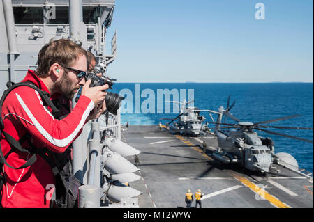 170720-N-RD713-066 CORAL SEA (20 luglio 2017) il personale dei media osservare le operazioni di volo da avvoltoio la fila durante un tour dell'assalto anfibio nave USS Bonhomme Richard (LHD 6) durante il talismano di Saber 17. Talismano Saber è una biennale degli STATI UNITI - Australia esercizio bilaterale tenutosi al largo della costa australiana intende conseguire l'interoperabilità e rafforzare gli Stati Uniti-Australia alliance. (U.S. Foto di Marina di Massa lo specialista di comunicazione di terza classe Zachary DiPadova/rilasciato) Foto Stock