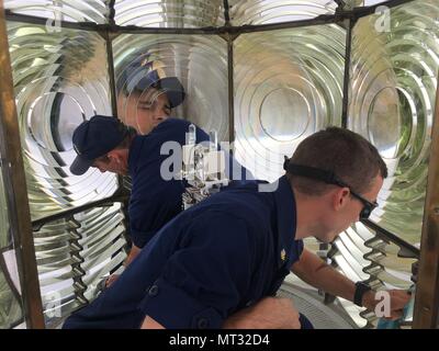 Coast Guard i membri di ausili alla navigazione Station Coos Bay pulire la lente all'interno del capo Blanco faro 50 miglia a sud di Coos Bay, Ore., luglio 18, 2017. Questo faro serve sia come ausilio di navigazione e un avviso di pericolo per le navi operanti in tutto il sud della costa dell'Oregon. Stati Uniti La guardia costiera della foto per gentile concessione di aiuti alla postazione di navigazione Coos Bay. Foto Stock