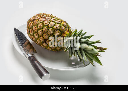 Ananas con Damasco Coltello sulla piastra bianca Foto Stock