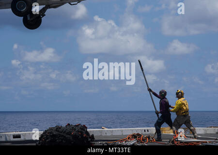 Oceano Pacifico (Luglio 19, 2017) di aviazione di Boatswain Mate (combustibili) terza classe Nicholas Regall (sinistra), nativo di Lisbona, Wisconsin, e il capo di aviazione di Boatswain Mate (combustibili) Joseph Mathews, nativo di Red Bluff, California, assegnato al dipartimento dell'aria a bordo il trasporto anfibio dock nave USS San Diego (LPD 22) preparare per agganciare il carico pendenti su un MH-60S Sea Hawk, assegnato al mare in elicottero Combat Squadron 23, durante un rifornimento verticale sulla nave del ponte di volo. San Diego è avviato una distribuzione programmata come parte dell'America anfibio gruppo pronto, il quale è costituito da Foto Stock