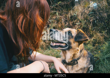 Guardare tra amici, un redhead ragazza e il suo cane Foto Stock