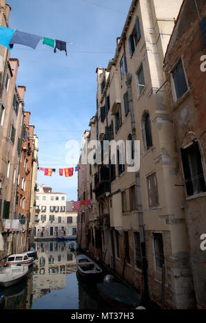 Servizio lavanderia in giornata a Venezia; vestiti appesi su canal Foto Stock