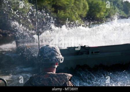 Attivi i soldati dell esercito dal 502nd Multi Role Bridge Co., guarda come sezione a ponte staffe sbloccare. Stati Uniti Esercito, attivo e soldati di riserva unirsi con Active e riserva componenti Marine per distribuire, costruire e assemblare un circa 320 metro galleggiante nastro migliorate ponte che attraversa il fiume Arkansas durante il fiume Assault 2017, a Fort Chaffee Centro di manovra, arca. Luglio 26, 2017. Fiume Assault 2017 è una di due settimane di combattimento prolungato esercizio di formazione detenuti luglio 15-28 concentrandosi sulle competenze tecniche di vari elementi di servizio, culminato con la costruzione di un galleggiante nastro migliorate di un ponte Foto Stock